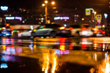 Büyük şehirde yağmurlu bir gece, yoğun bir kavşakta yoğun bir trafik.