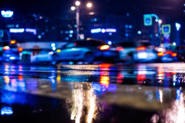 Büyük şehirde yağmurlu bir gece, yoğun bir kavşakta yoğun bir trafik.