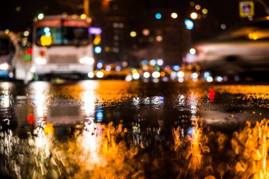 Büyük şehirde yağmurlu bir gece, yoğun bir kavşakta yoğun bir trafik.