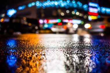 Büyük şehirde yağmurlu bir gece, kör edici bir yaklaşımın farları