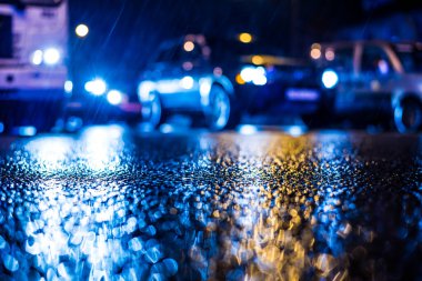 Büyük şehirde yağmurlu bir gece, yoğun bir caddede akşam trafiği sıkışık.