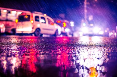 Büyük şehirde yağmurlu bir gece, kör edici bir yaklaşımın farları