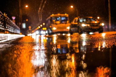 Büyük şehirde yağmurlu bir gece. Trav arabalarının farları yaklaşıyor.