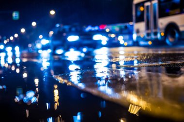 Büyük şehirde yağmurlu bir gece, yoğun bir kavşakta yoğun bir trafik.