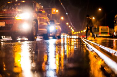 Büyük şehirde yağmurlu bir gece, kör edici bir yaklaşımın farları