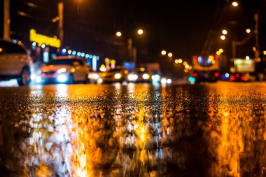 Büyük şehirde yağmurlu bir gece, yoğun bir caddede yoğun trafik.