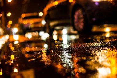 Büyük şehirde yağmurlu bir gece. Trav arabalarının farları yaklaşıyor.