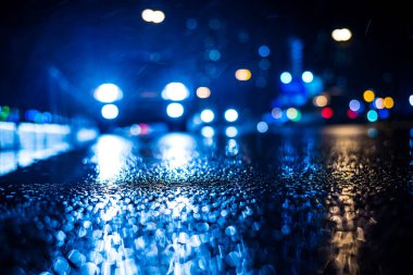 Büyük şehirde yağmurlu bir gece, Trave arabasının farları yaklaşıyor.