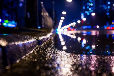 Büyük şehirde yağmurlu bir gece. Trav arabalarının farları yaklaşıyor.