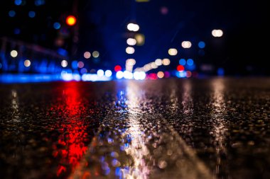 Büyük şehirde yağmurlu bir gece, yaklaşan ışıkların parlaklığı