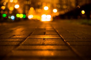 Büyük şehirde yağmurlu bir gece, öndeki ışıkları kör ediyor.