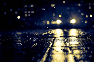 Büyük şehirde yağmurlu bir gece, kör edici bir yaklaşımın farları