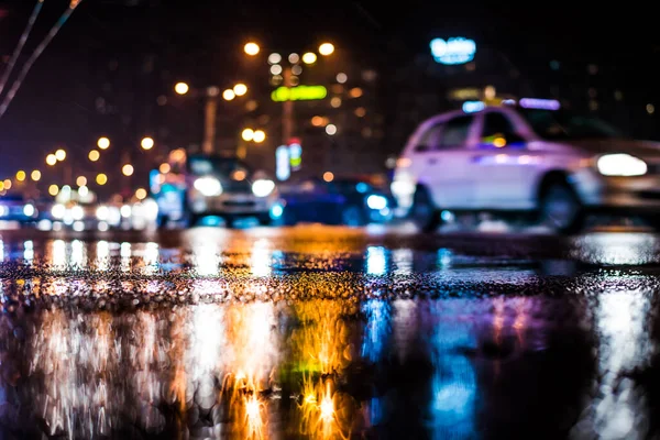 Büyük şehirde yağmurlu bir gece, yoğun bir kavşakta yoğun bir trafik.