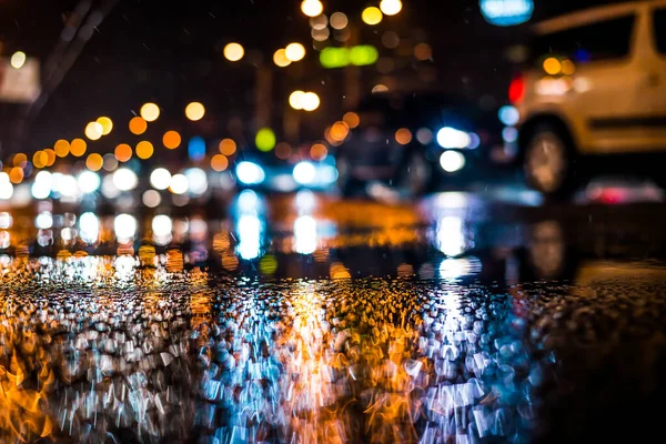 Büyük şehirde yağmurlu bir gece, yoğun bir kavşakta yoğun bir trafik.