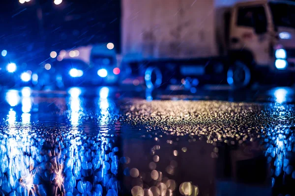 Büyük şehirde yağmurlu bir gece, yoğun bir kavşakta yoğun bir trafik.