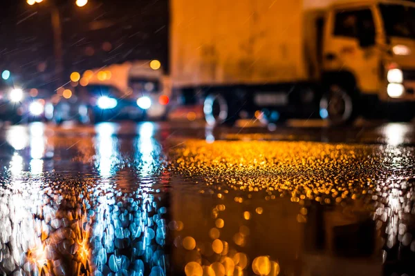 Büyük şehirde yağmurlu bir gece, yoğun bir kavşakta yoğun bir trafik.