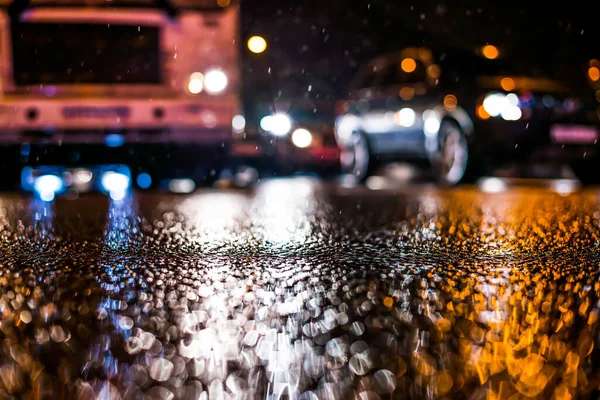 Büyük şehirde yağmurlu bir gece, yoğun bir caddede akşam trafiği sıkışık.