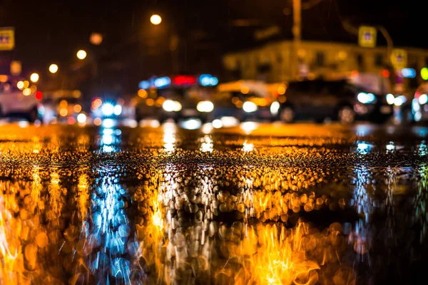 Büyük şehirde yağmurlu bir gece, yoğun bir kavşakta yoğun bir trafik.