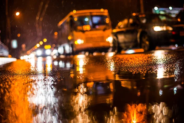 Büyük şehirde yağmurlu bir gece. Trav arabalarının farları yaklaşıyor.