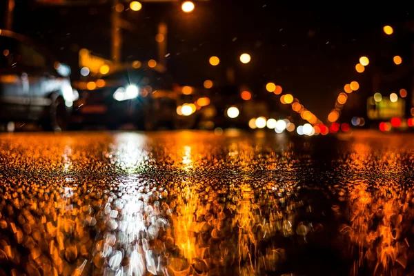 Büyük şehirde yağmurlu bir gece, yoğun bir caddede yoğun trafik.