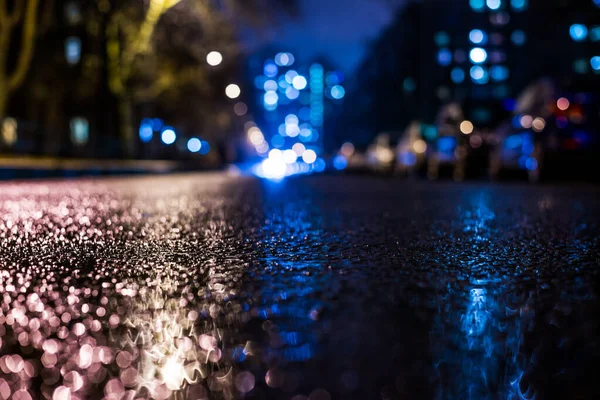 Rainy night in the big city, approaching headlights of cars trav