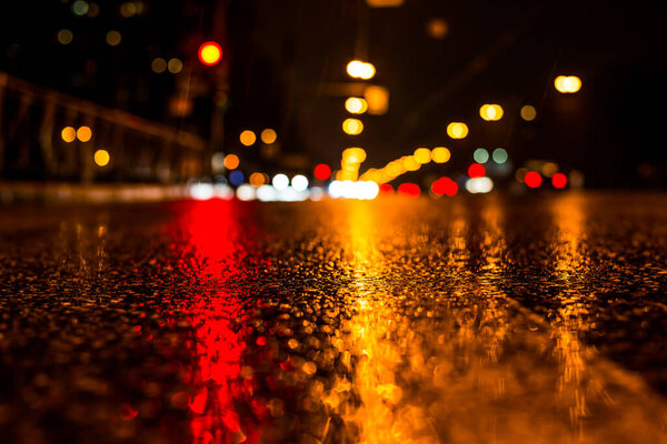 Rainy night in the big city, the glowing lights of approaching c