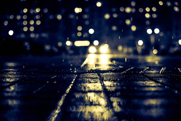 Büyük şehirde yağmurlu bir gece, kör edici bir yaklaşımın farları