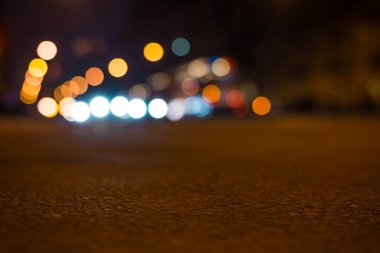 Büyük şehrin gece ışıkları, asfalt seviyesinden manzarayı kapatın. 