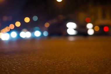 Büyük şehrin gece ışıkları, asfalt seviyesinden manzarayı kapatın. 