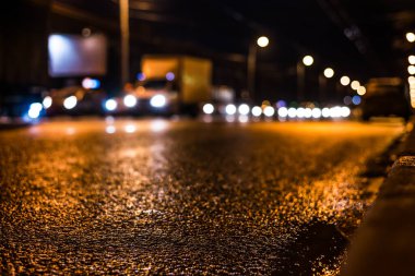 Gece üstüne yağmur, yandan gelen arabaların manzarası.