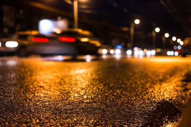 Gece üstüne yağmur, kaldırımdaki yarış arabasının manzarası...