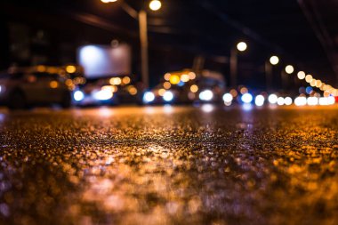 Gece üstüne yağmur, yandan gelen arabaların manzarası.