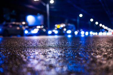 Gece üstüne yağmur, yandan gelen arabaların manzarası.