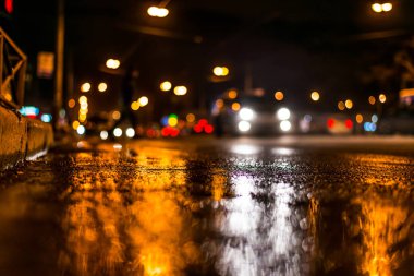 Gece gündüz yağmur yağıyor, kaldırımdan arabaların akışını görüyorum.