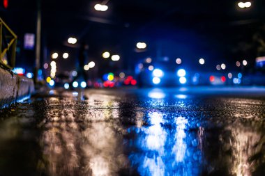 Gece gündüz yağmur yağıyor, kaldırımdan arabaların akışını görüyorum.