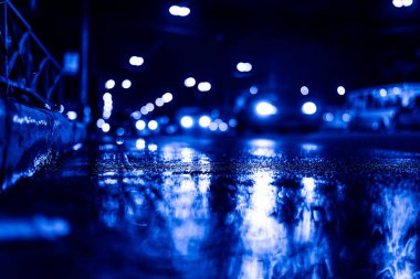 Gece gündüz yağmur yağıyor, kaldırımdan arabaların akışını görüyorum.