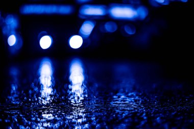 Gece araba farları parlıyor. Asfalt seviyesinden görüntüle