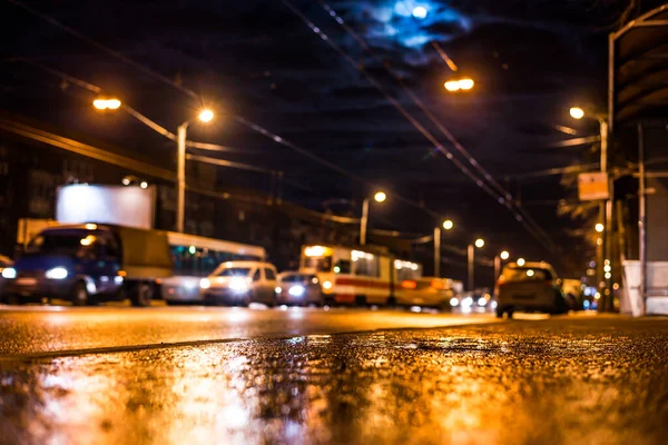 Night city after rain, the moon over the road on which the car r