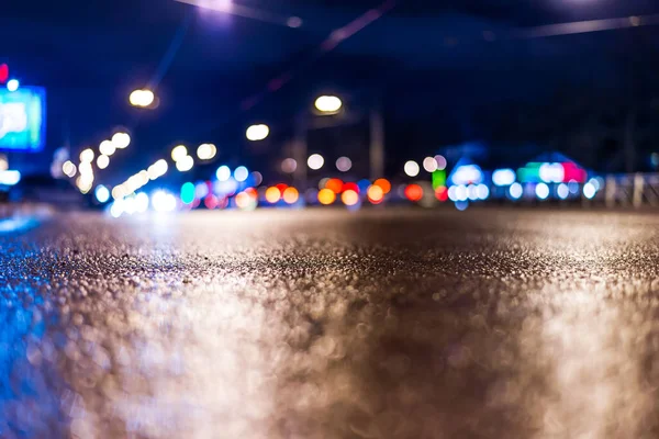 View of the city at night after the rain, the cars driving on th