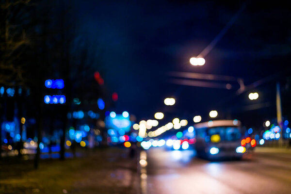 View of the city at night after the rain, the bus driving on the