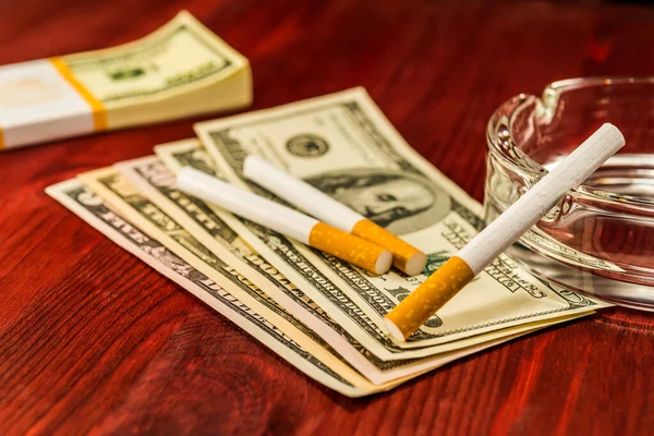Dvě Cigarety Jsou Dolarech Leží Vedle Krabičky Bankovek — Stock fotografie