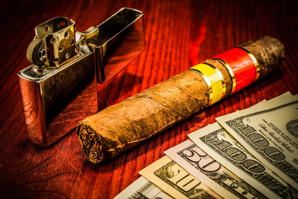 Cuban cigar and a several dollar bills with lighter on the table