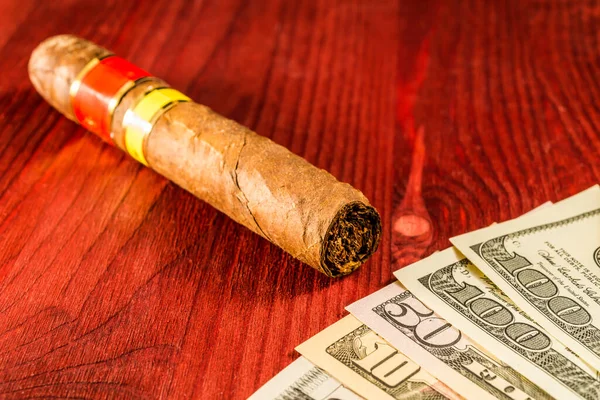 Cuban cigar and a several dollar bills  on the table.