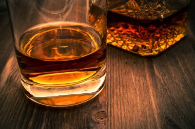 Bir bardak viski ve bir bardak da tahta masada.