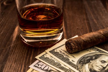 Bir bardak viski ve üzerinde Küba purosu olan bir para..