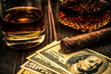 Bir bardak viski, bir bardak Küba purosu ve para. 
