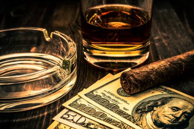 Bir bardak viski ve üzerinde Küba purosu olan bir para..