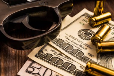 Tabanca tetikleyicisi, fişekler ve tahtanın üzerinde para var.