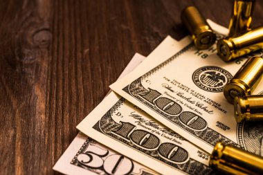 Mermiler ve para ahşap masada. Görüntüyü kapat