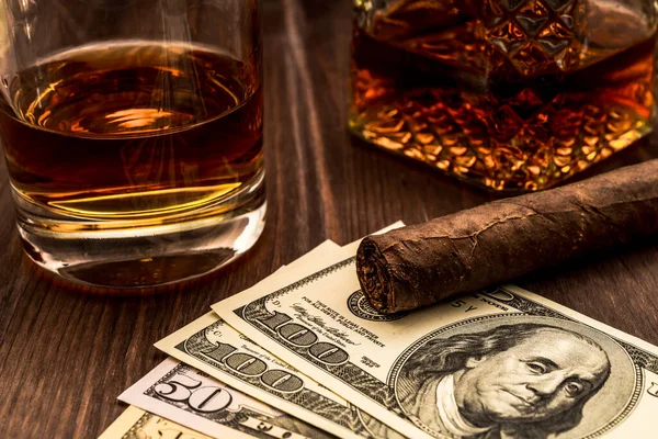 Bir bardak viski, bir bardak Küba purosu ve para. 